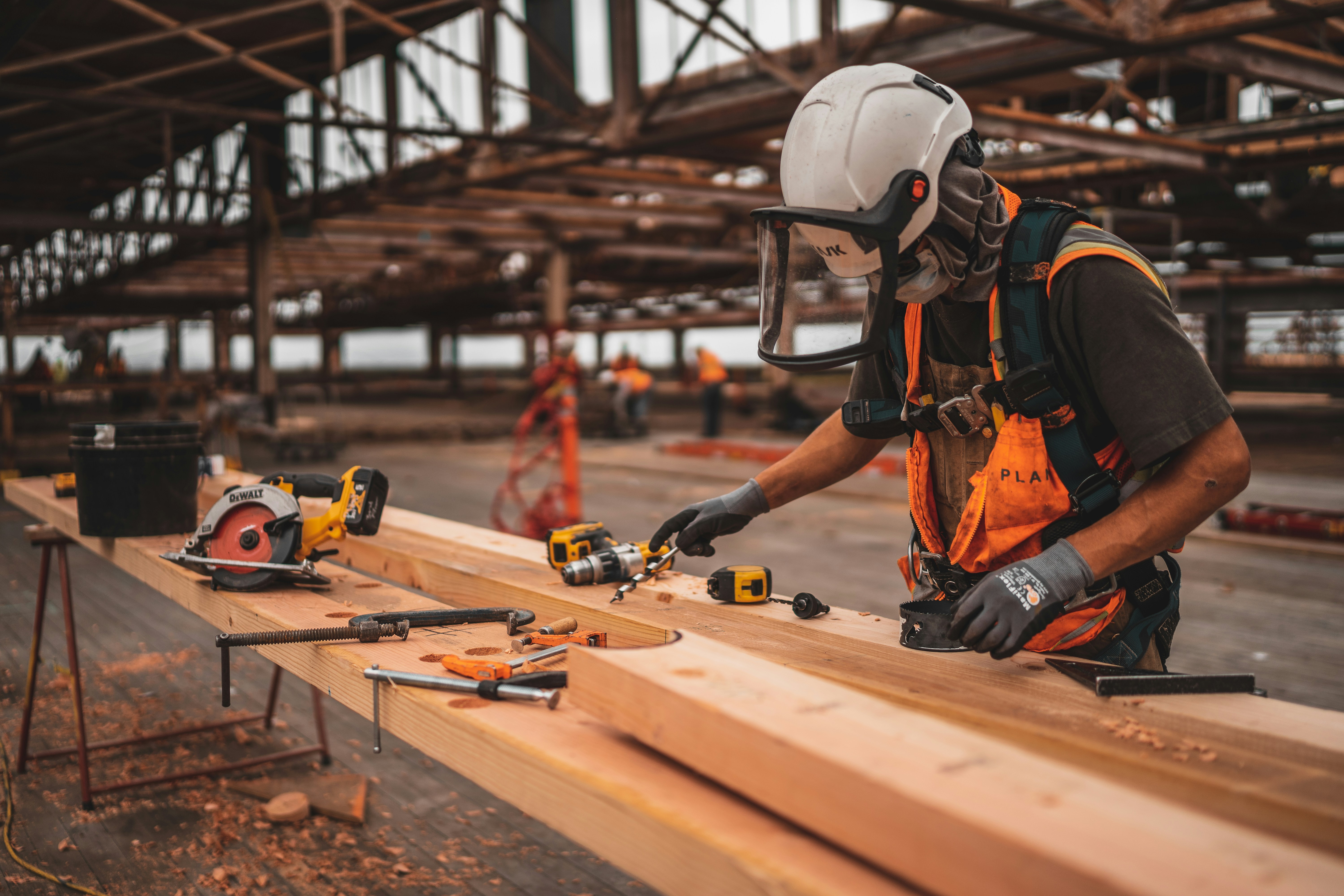 Builder measuring and cutting timber on a job site